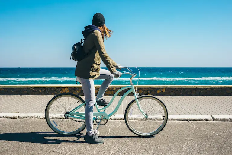 海沿いでサイクリングする女性